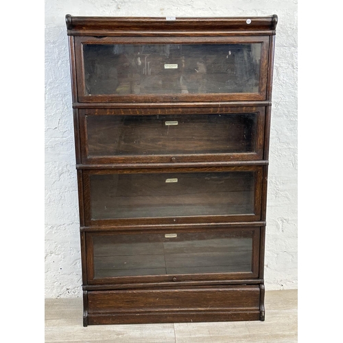 1 - An early 20th century Globe-Wernicke oak four section stacking bookcase - approx. 141cm high x 86cm ... 