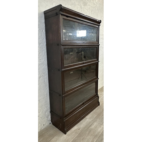 1 - An early 20th century Globe-Wernicke oak four section stacking bookcase - approx. 141cm high x 86cm ... 