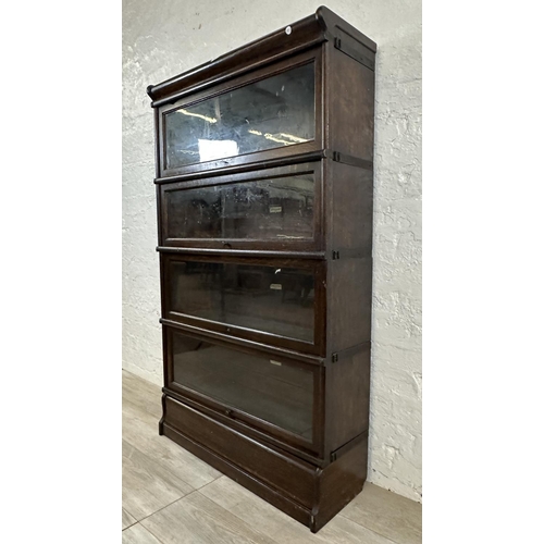 1 - An early 20th century Globe-Wernicke oak four section stacking bookcase - approx. 141cm high x 86cm ... 