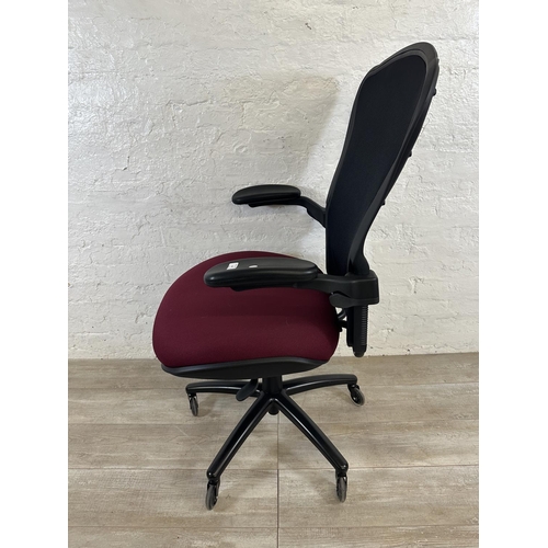 100 - A modern black plastic and meshed swivel office desk chair