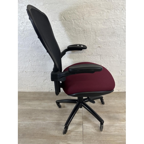 100 - A modern black plastic and meshed swivel office desk chair