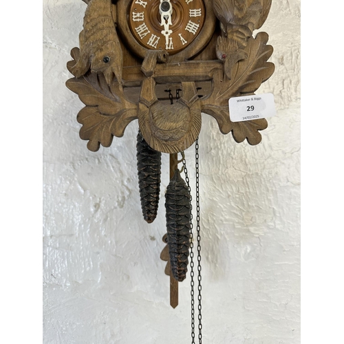 29 - A mid 20th century West German Black Forest carved wooden cuckoo clock - approx. 49cm high including... 