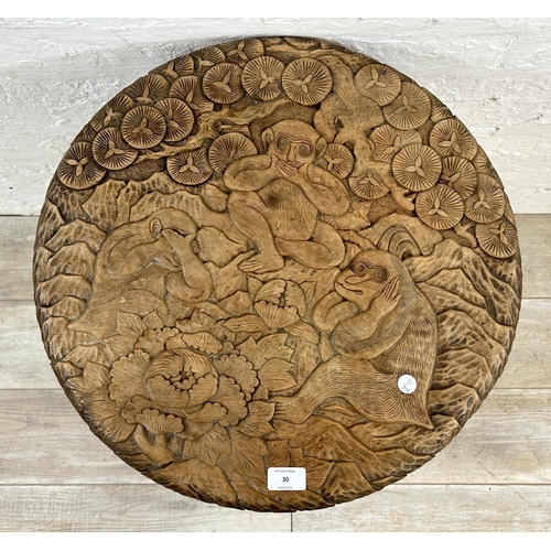 30 - An Arts & Crafts Liberty & Co carved hardwood circular side table with three monkey design and numbe... 