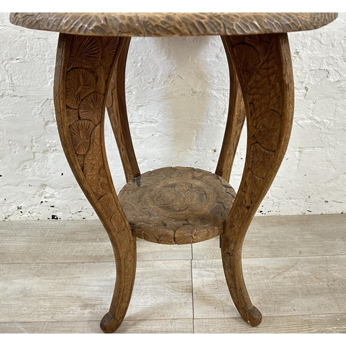 30 - An Arts & Crafts Liberty & Co carved hardwood circular side table with three monkey design and numbe... 