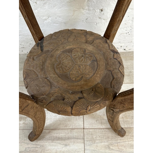 30 - An Arts & Crafts Liberty & Co carved hardwood circular side table with three monkey design and numbe... 