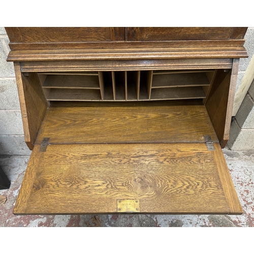 43 - An early 20th century oak bureau bookcase with two stained and lead glazed doors - approx. 194cm hig... 