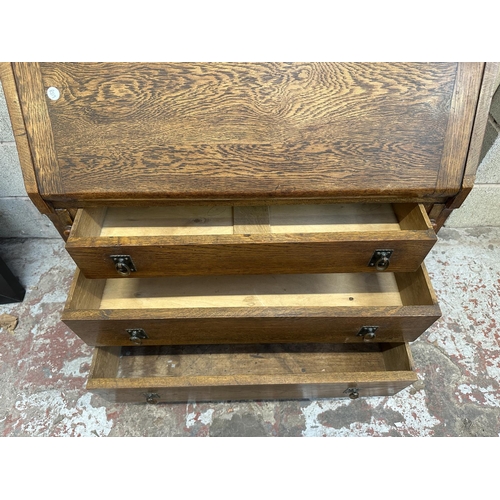 43 - An early 20th century oak bureau bookcase with two stained and lead glazed doors - approx. 194cm hig... 