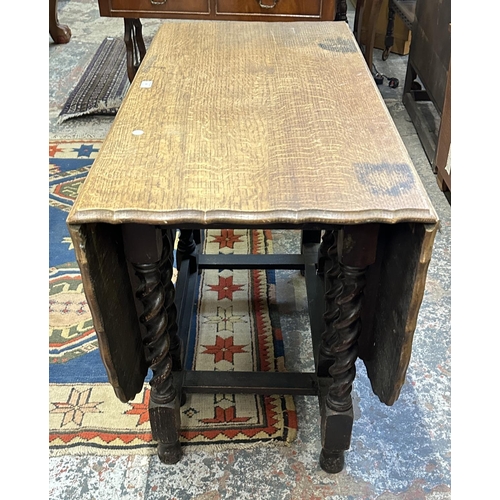 58 - An early 20th century oak pie crust edge drop leaf gate leg barley twist dining table