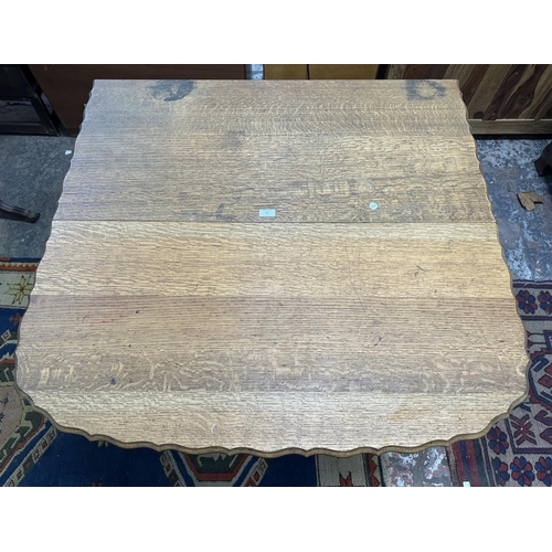 58 - An early 20th century oak pie crust edge drop leaf gate leg barley twist dining table