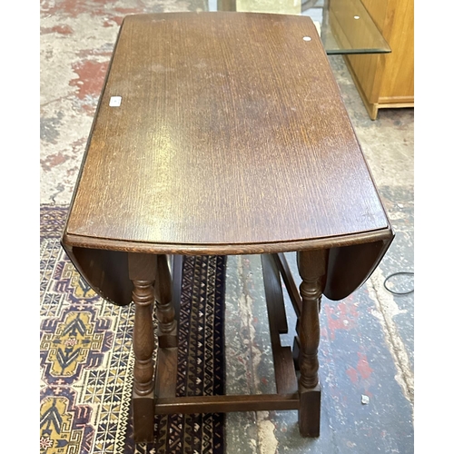 63 - A 17th century style oak drop leaf gate leg dining table