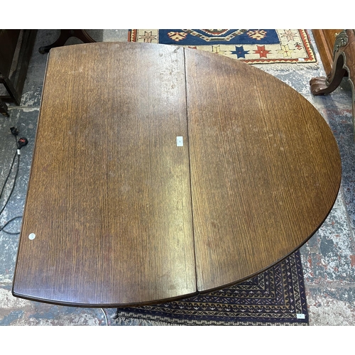 63 - A 17th century style oak drop leaf gate leg dining table