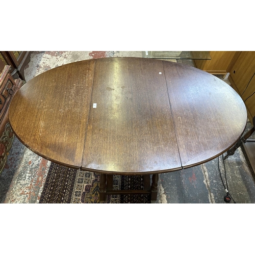 63 - A 17th century style oak drop leaf gate leg dining table