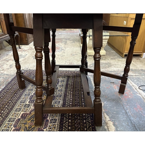 63 - A 17th century style oak drop leaf gate leg dining table