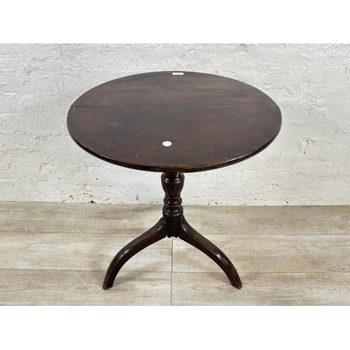 64 - A George III oak circular tilt top tripod side table - approx. 68cm high x 57cm diameter