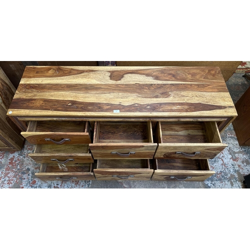 77 - An Indian sheesham wood chest of drawers - approx. 66cm high x 145cm wide x 45.5cm deep