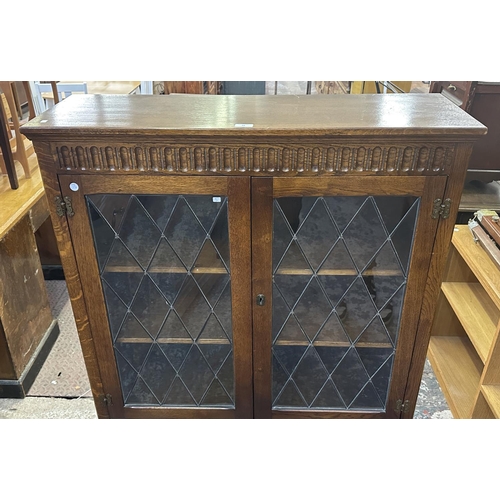 93 - A Priory style carved oak and lead glazed bookcase - approx. 137cm high x 96cm wide x 31cm deep