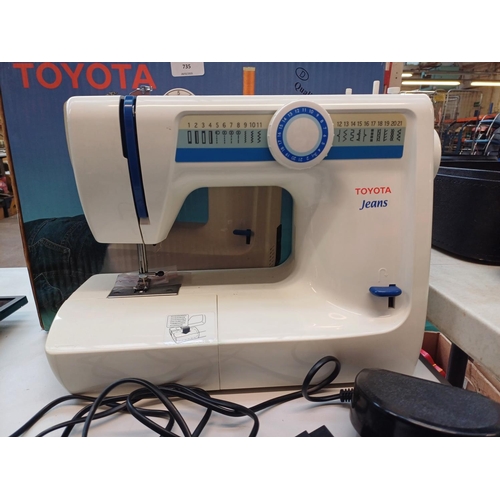 735 - A boxed Toyota Jeans 21 stitch programme electric sewing machine with foot pedal