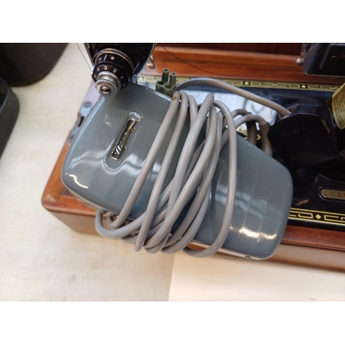 737 - A cased 1955 Singer 99K electric sewing machine with foot pedal, fitted light, accessories and key