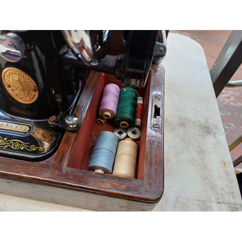 738 - A cased 1939 Singer 99K hand crank sewing machine with boxed attachments, accessories and key