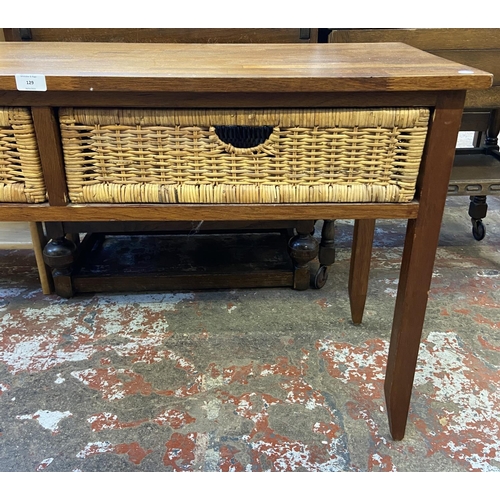 129 - A modern hardwood and wicker two drawer console table - approx. 71cm high x 125cm wide x 45cm deep