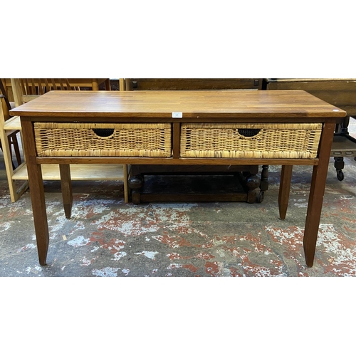 129 - A modern hardwood and wicker two drawer console table - approx. 71cm high x 125cm wide x 45cm deep