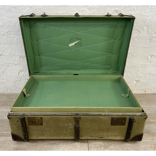 138 - An early/mid 20th century wooden banded green canvas and brown leather travel trunk, patent no. 2316... 