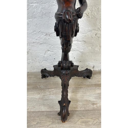 15 - A 19th century carved walnut tripod pedestal jardinière stand with putti design - approx. 95cm high