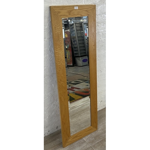 194 - A modern oak framed bevelled edge wall mirror - approx. 140cm high x 48cm wide