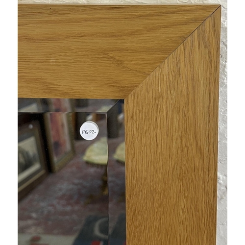 194 - A modern oak framed bevelled edge wall mirror - approx. 140cm high x 48cm wide