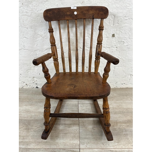 23 - A Victorian elm and beech spindle back child's rocking chair - approx. 72cm high x 44cm wide x 52cm ... 