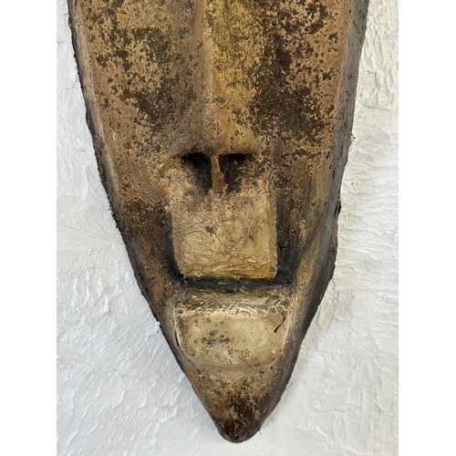 33 - A fibreglass African tribal wall hanging mask - approx. 65cm high