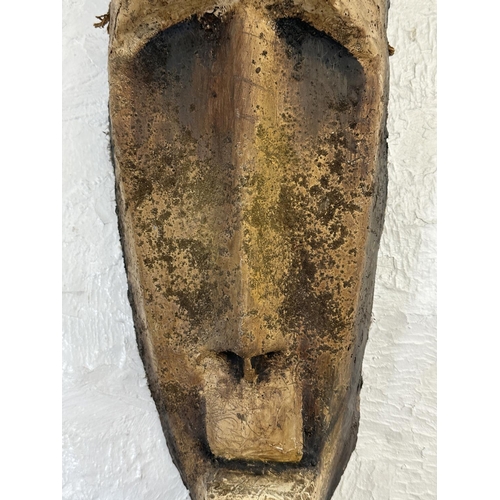 33 - A fibreglass African tribal wall hanging mask - approx. 65cm high