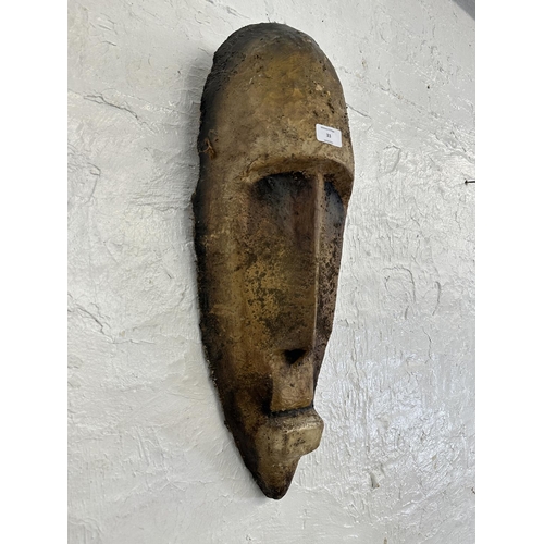 33 - A fibreglass African tribal wall hanging mask - approx. 65cm high