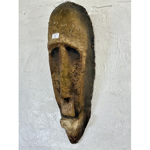 33 - A fibreglass African tribal wall hanging mask - approx. 65cm high