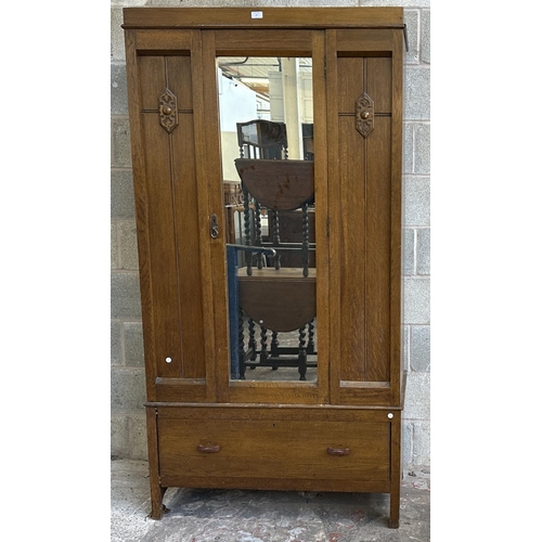 67 - An early 20th century carved oak mirror door wardrobe - approx. 196cm high x 100cm wide x 47cm deep