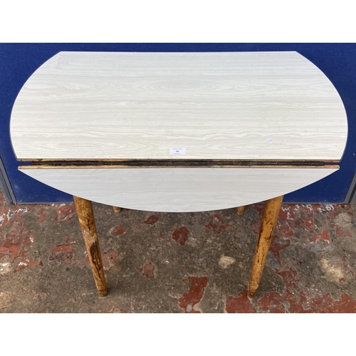 80 - A mid 20th century white melamine and beech drop leaf kitchen table - approx. 75cm high x 86cm wide ... 