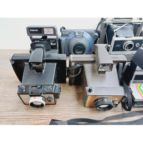 950 - Twelve instant cameras to include Fujifilm Instax 100, Polaroid The Button, Polaroid 636 Close-Up, P... 