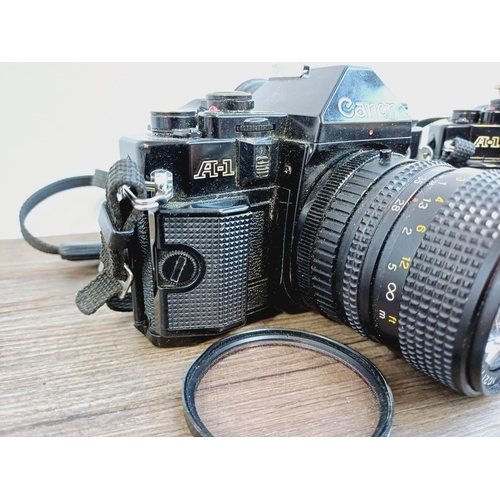 949 - Two Canon A-1 35mm SLR cameras, one fitted with Makinon MC 1:3.5-4.5 28-80mm auto zoom lens and one ... 