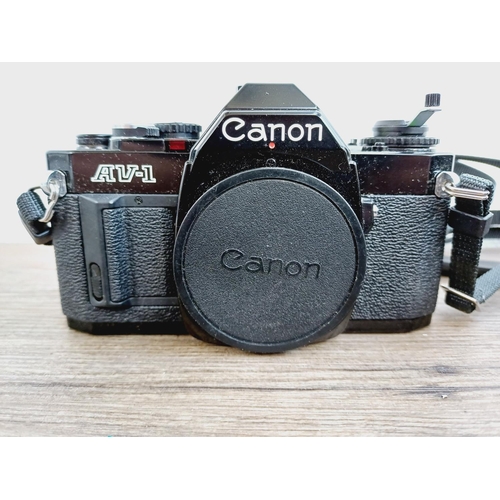 953 - Two Canon 35mm SLR cameras, one A-1 fitted with FD 1:1.8 50mm lens and one AV-1 body