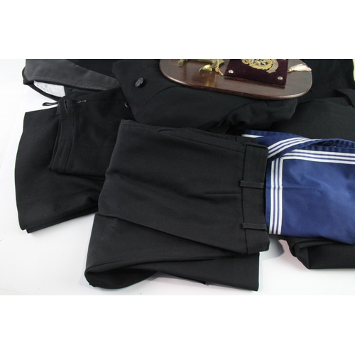 779 - A collection of Navy items to include wall plaque, tunics, trousers etc.