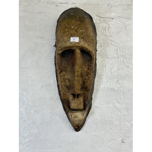 57 - A fibreglass African tribal wall hanging mask - approx. 65cm high