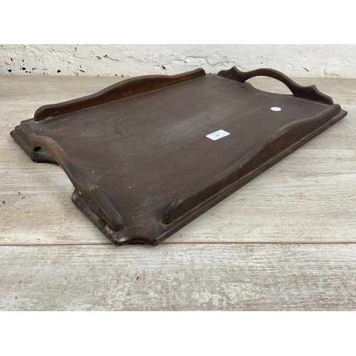 85 - Two items, one early 20th century beech twin handled tray and one beech and brown leather footstool
