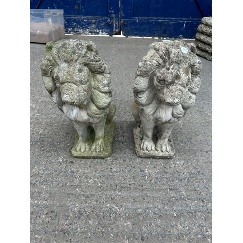 341 - A pair of cast stone lion garden ornaments - approx. 45cm high