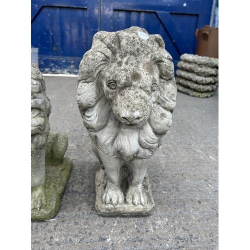 341 - A pair of cast stone lion garden ornaments - approx. 45cm high