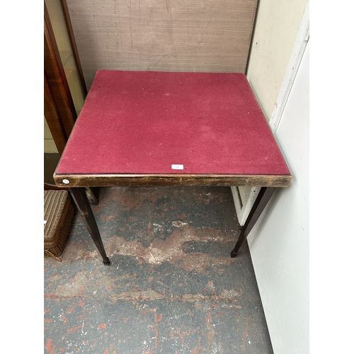 357 - An early/mid 20th century wooden folding games table with burgundy felt top - approx. 70cm high x 76... 