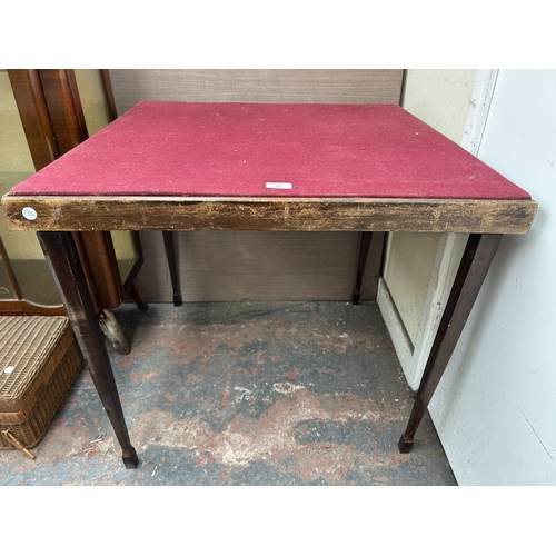 357 - An early/mid 20th century wooden folding games table with burgundy felt top - approx. 70cm high x 76... 