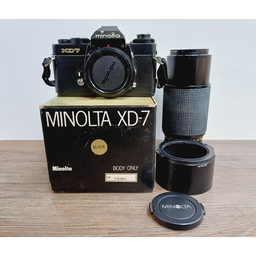 1072 - A boxed black Minolta XG7 35mm SLR camera body with MD 1:4 70-210mm zoom lens with caps, filter and ... 