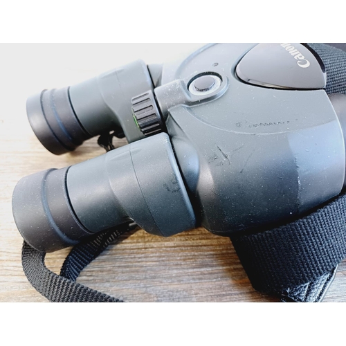 1077 - A cased pair of Canon 10x30 IS Image Stabilizer binoculars with instruction manual