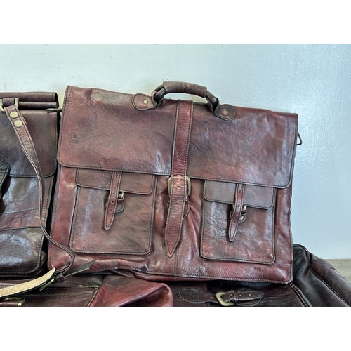 733 - Five red dyed leather accessories, three holdalls and two satchels