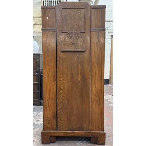 110 - An Art Deco carved oak single door wardrobe - approx. 170cm high x 74cm wide x 41cm deep